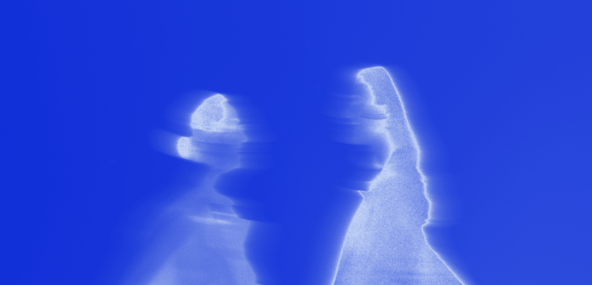 Duas pessoas em movimento, com os corpos parcialmente sobrepostos e desfocados, em uma composição abstrata iluminada em tons intensos de azul e branco.